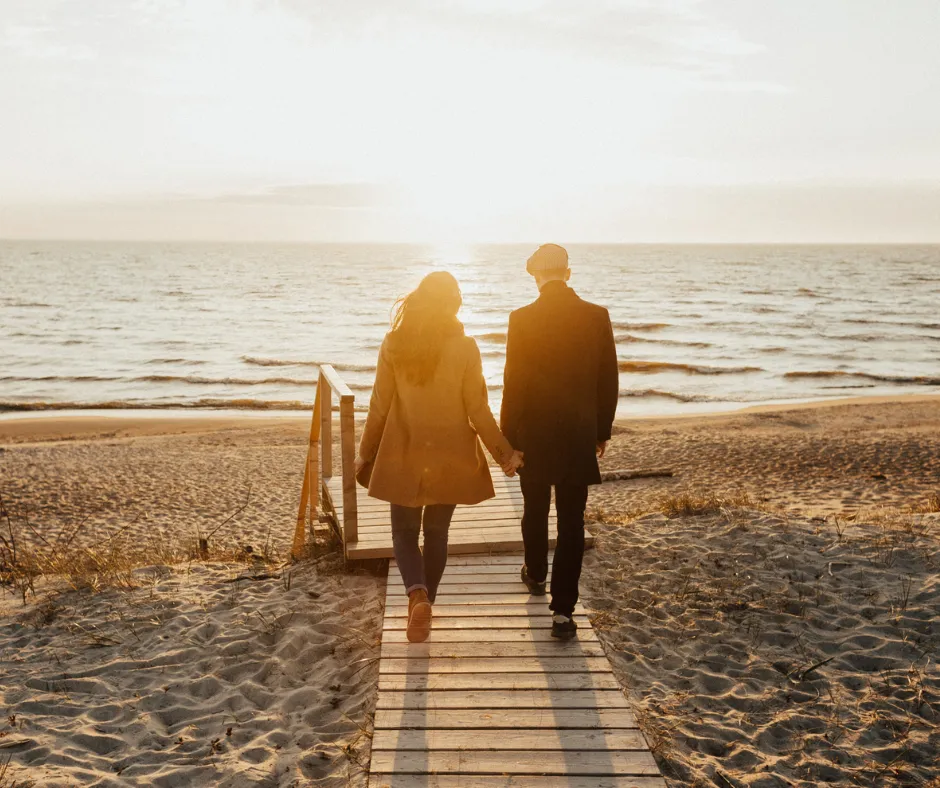 Un couple marchant main dans la main dans un cadre naturel